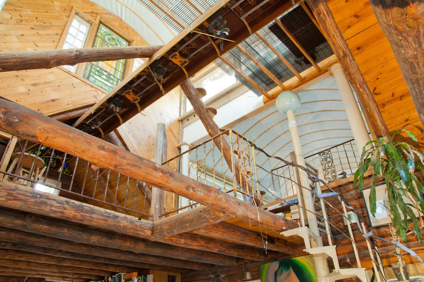 Log beams, iron railings and a spiral staircase under the 35-foot ceiling