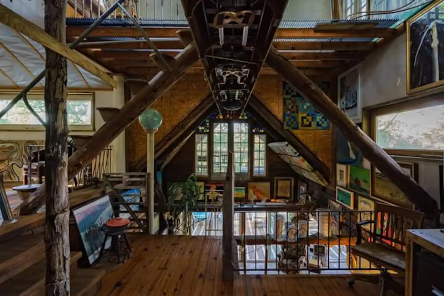 The main room of the cabin, with a rowing scull mounted upside down along the ridge above a wall of paintings